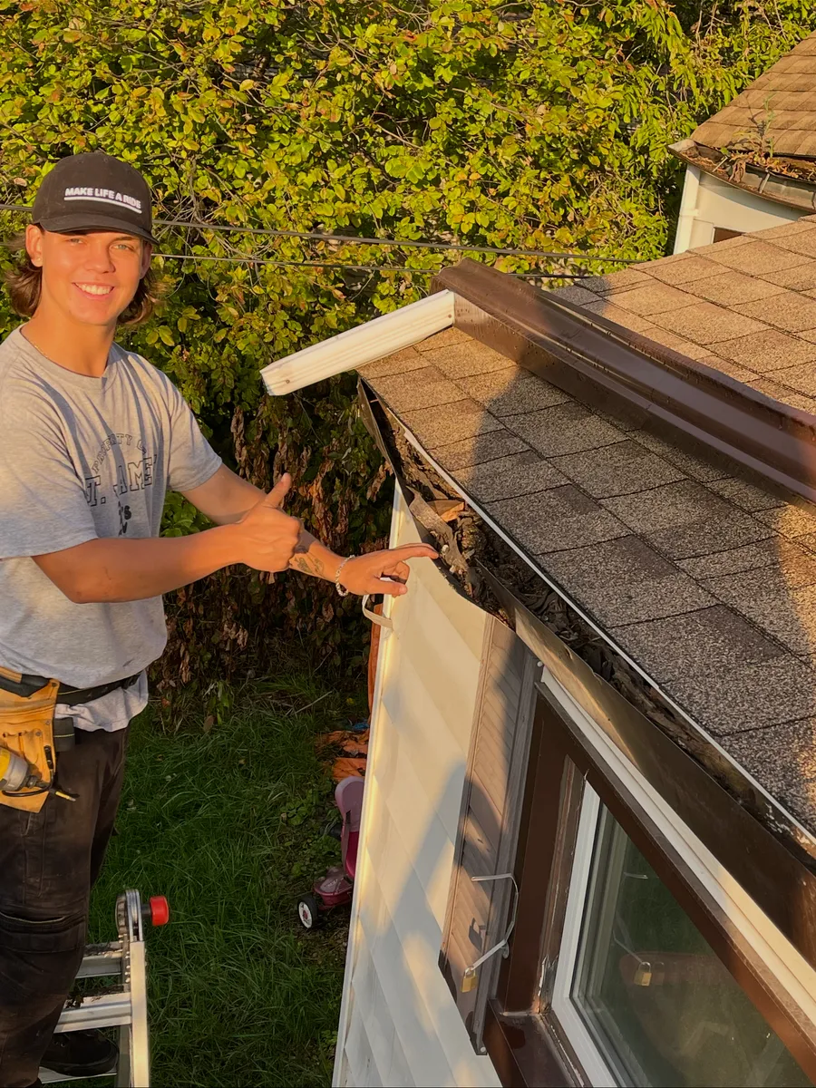 Nathanial Steinmann installing gutters on a residential home in Alberta