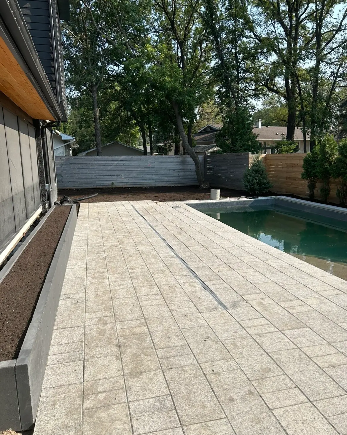 Modern paver patio with cedar deck at dusk, a recent Steinmann Homes project